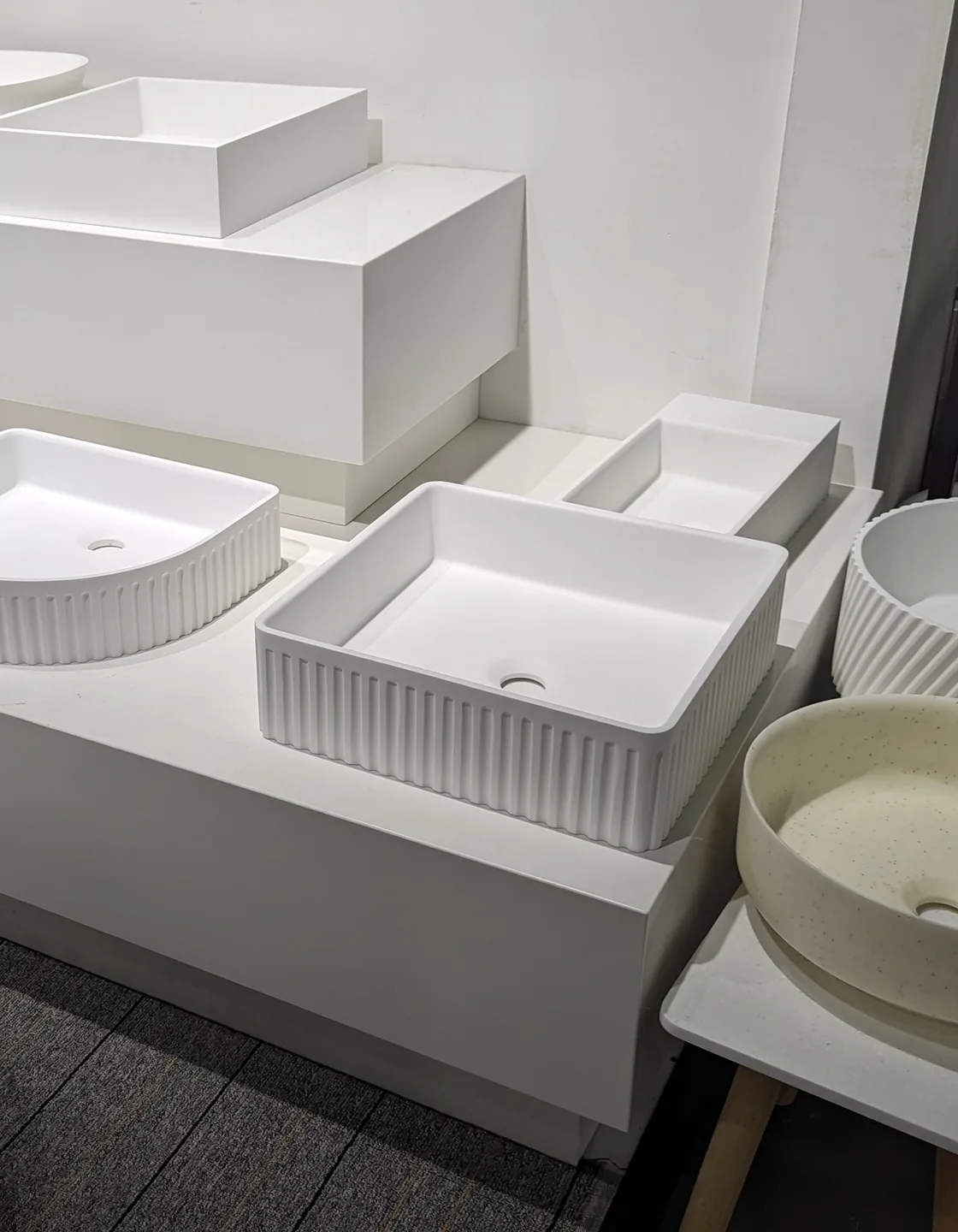 Range of ceramic and solid surface basins on showroom display