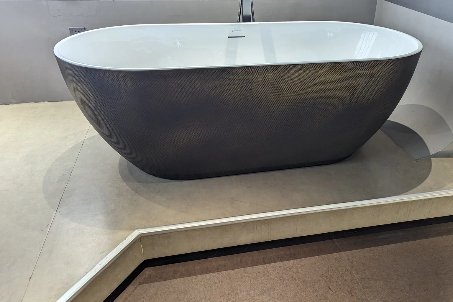 Freestanding bath with a textured dark exterior and gloss white interior