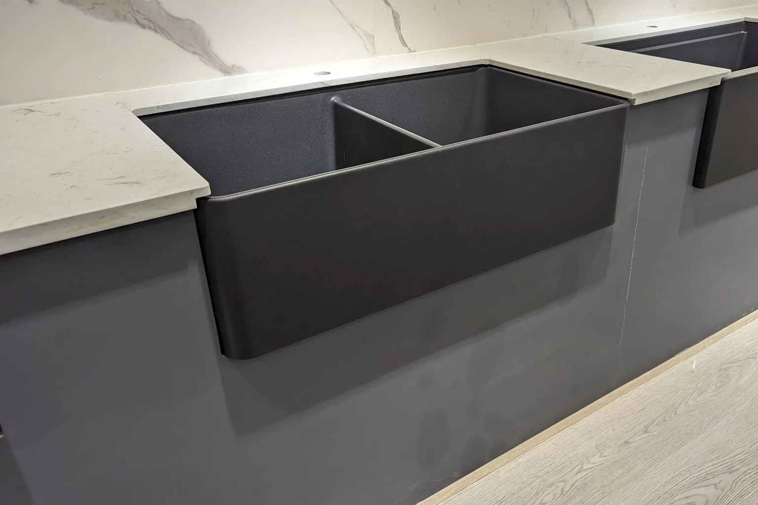 Granite composite apron front butler sink installed in a stone benchtop