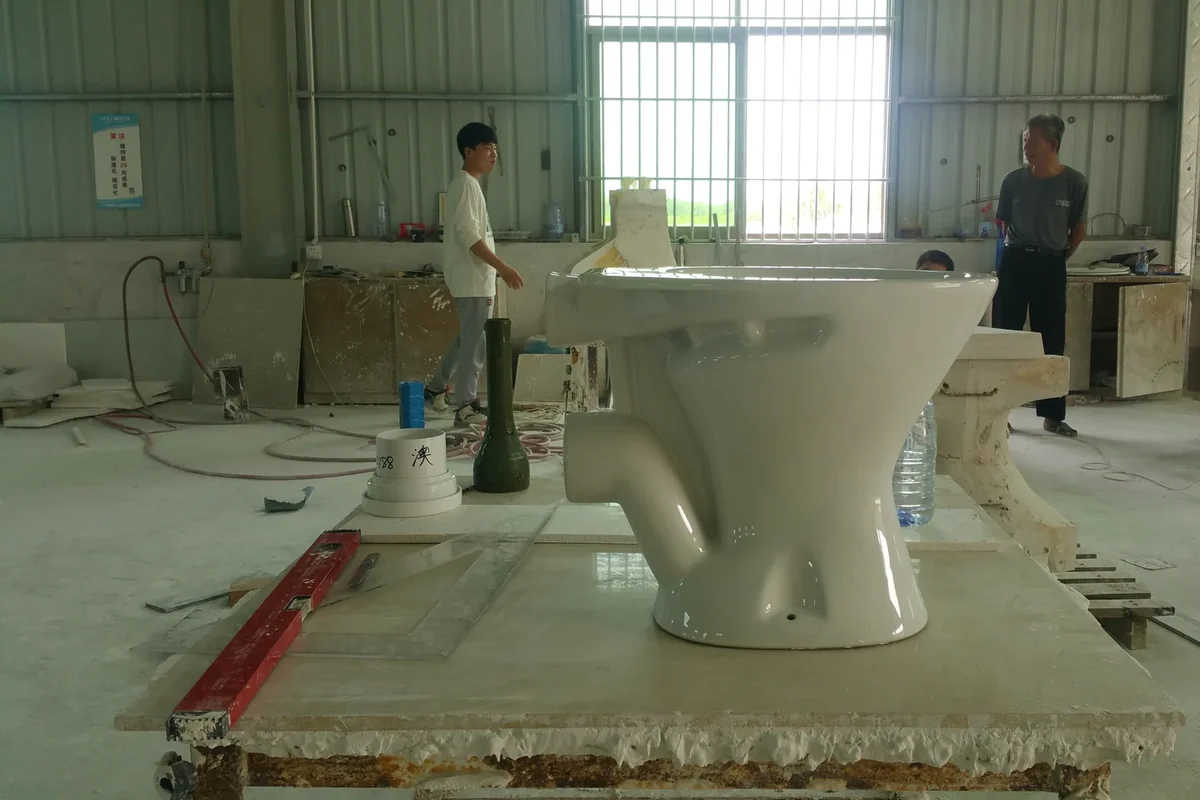 Ceramic toilet pan being checked on the factory floor